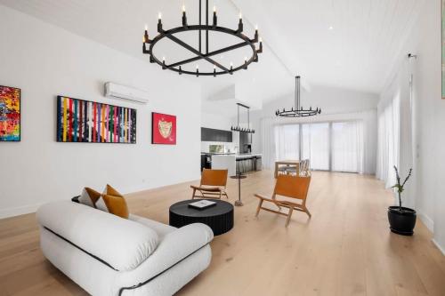 a living room with a white couch and a chandelier at Casa del Candelabra - Light-Filled Luxury Retreat Minutes from Town in Bellbrae