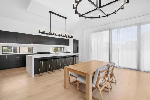 a kitchen with a wooden table and a large clock at Casa del Candelabra - Light-Filled Luxury Retreat Minutes from Town in Bellbrae