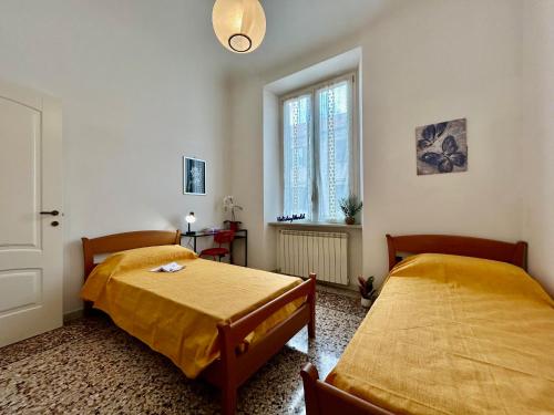 a bedroom with two beds and a window at Casa Tulipani by Holiday World in Savona