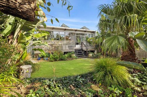 a garden with a house with windows and plants at Jan Juc Garden Sanctuary Steps from the Surf in Torquay