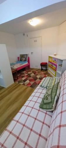a bedroom with a bed and a checkerboard floor at Apartamento do jardim in Cascais