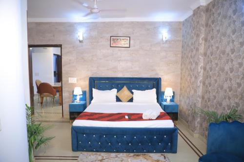 a bedroom with a bed with a blue headboard at Fortune Home Service Apartment 3Bhk , D-198 Saket in New Delhi