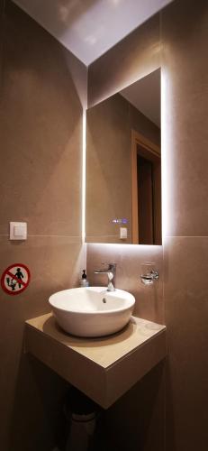 a bathroom with a white sink and a mirror at Casa Mameli Αpartments in Kallithea Halkidikis