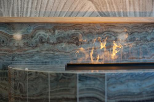 a fireplace with a fire inside of it at Latemar - Hotel Suites Spa in Soraga