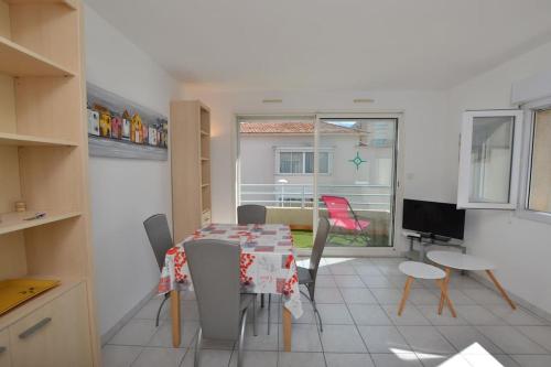une cuisine avec une table et des chaises dans une pièce dans l'établissement Le Baroncelli sur la plage, au Grau-du-Roi