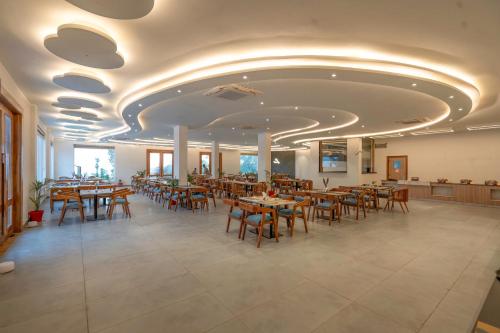 Evara Spa & Resort في رامناجار: مطعم فيه طاولات وكراسي في الغرفة