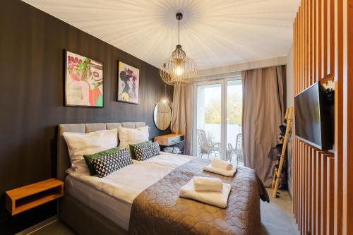 ein Schlafzimmer mit einem großen Bett und einem TV in der Unterkunft Loft House by Perłowa Przystań Rent in Kołobrzeg