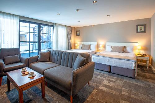 um quarto de hotel com uma cama, um sofá e uma cama em Aston Hotel Taksim em Istambul