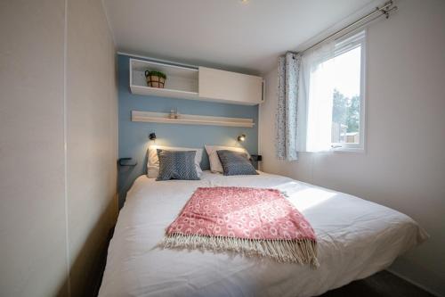 um quarto com uma cama com um cobertor vermelho em Camping het Wieskamp em Henxel