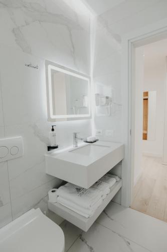 a white bathroom with a sink and a toilet at Seaside Hotel in Vlorë