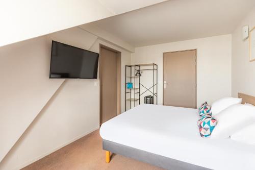 a bedroom with a bed and a tv on the wall at Appart’City Confort Reims Centre in Reims