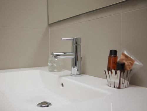 lavabo con grifo y cepillos de dientes en Hotel Sole en Cannero Riviera