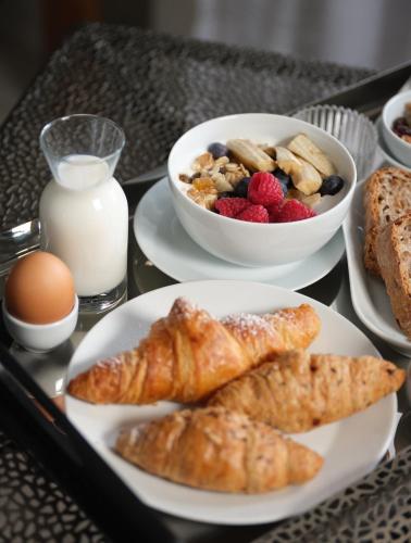 a tray with plates of breakfast foods and milk at Hotel Sole in Cannero Riviera