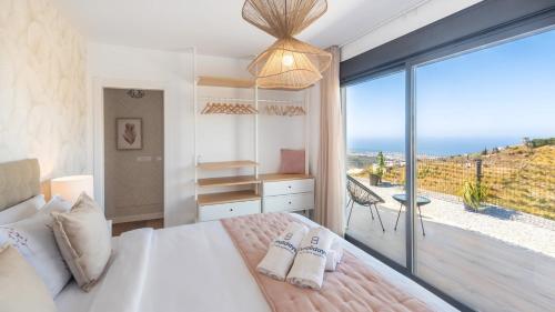 a bedroom with a bed and a view of the ocean at Villa Turística Palomas Torrox by Ruralidays in Torrox