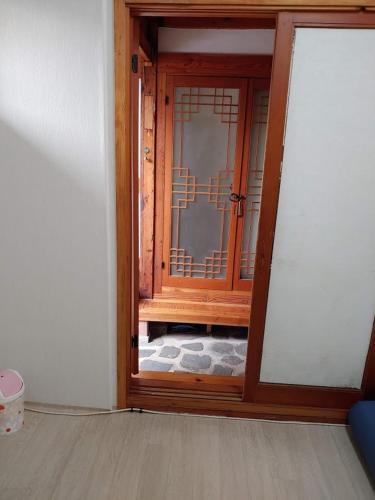 an open door to a room with a glass at Inwoo Guesthouse in Seoul