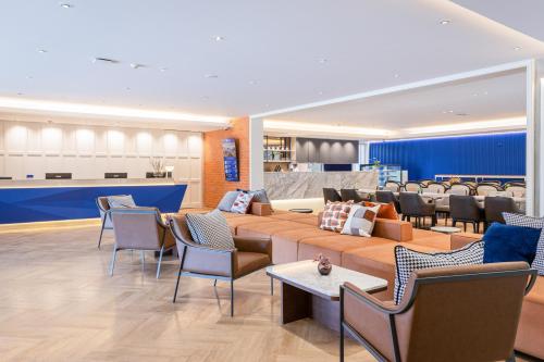 een lobby met een bank, stoelen en een tafel bij Blue Hippo Hotel in Ban Khlong Samrong