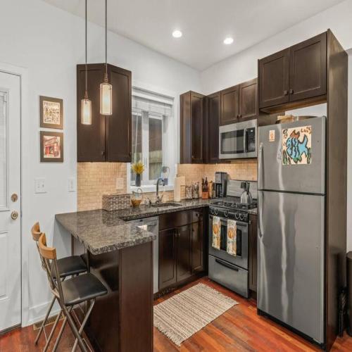 a kitchen with a stainless steel refrigerator and wooden cabinets at Bright & Modern Home with Patio in Philadelphia