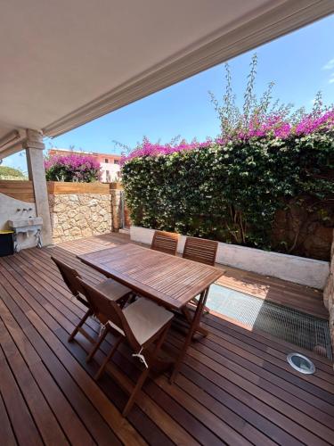 a wooden table and chairs on a wooden deck at Appartamento a due passi dal mare in Palau