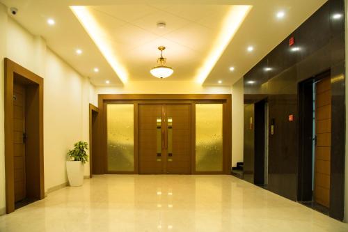 korytarz z dużymi drewnianymi drzwiami w budynku w obiekcie Hotel LA PEARL, Bhopal w mieście Bhopal