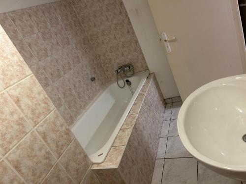 une salle de bain avec une baignoire et un lavabo dans l'établissement Appartement, à Sainte-Marie-aux-Mines