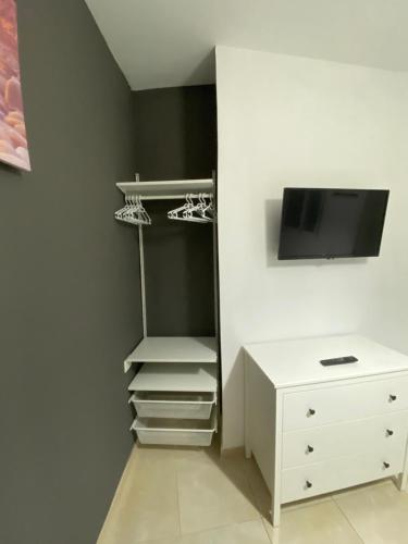 a closet with a tv and a white dresser at DELUXE ROOM IN APARTMENT SHARED in Los Cristianos Playa HabitaciónSTANZA air-conditioned in Arona