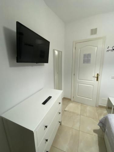 a white dresser with a flat screen tv on a wall at DELUXE ROOM IN APARTMENT SHARED in Los Cristianos Playa HabitaciónSTANZA air-conditioned in Arona