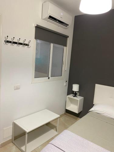 a white bedroom with a bed and a window at DELUXE ROOM IN APARTMENT SHARED in Los Cristianos Playa HabitaciónSTANZA air-conditioned in Arona
