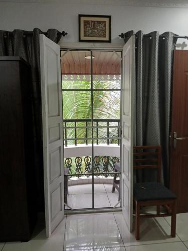 an open door with a chair and a balcony at annies inn homestay in Cochin