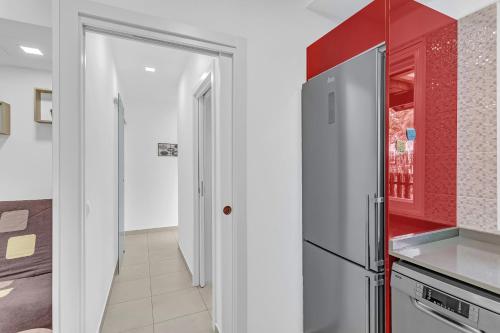 a kitchen with red and white walls and a refrigerator at Casarossa in Maspalomas