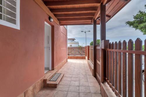 an empty walkway of a house with a fence at Casarossa in Maspalomas