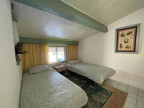 une chambre avec deux lits et une fenêtre dans l'établissement Résidence de charme à Grasse, à Grasse