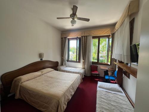ein Hotelzimmer mit 2 Betten und einem Deckenventilator in der Unterkunft Hotel Cristallo in Lido di Venezia