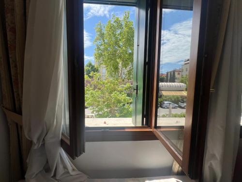 a window with a view of a tree at Hotel Cristallo in Venice-Lido