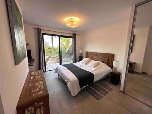 une chambre avec un grand lit et une grande fenêtre dans l'établissement Villa privée-piscine-vue mer-pinarello-cirindinu, à Zonza