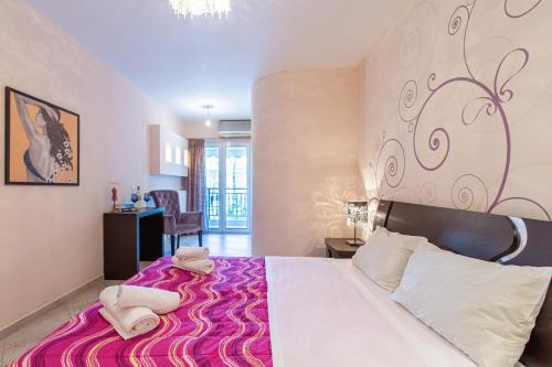 a bedroom with a large bed with a purple blanket at Elena Apartment in Chania