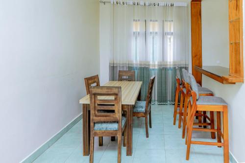 Un comedor con mesa y sillas de madera. en Kigali Wings Apartment 2 C, en Kigali