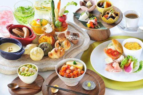una tabella piena di diversi tipi di alimenti su piatti di OMO7 Osaka by Hoshino Resorts ad Osaka