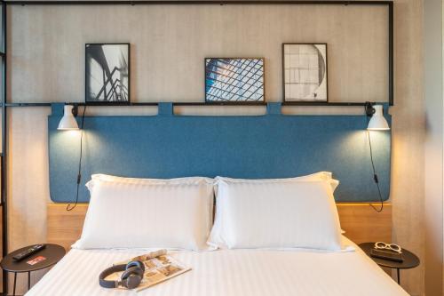 a bedroom with a bed with two white pillows at ibis Paris CDG Airport in Roissy-en-France