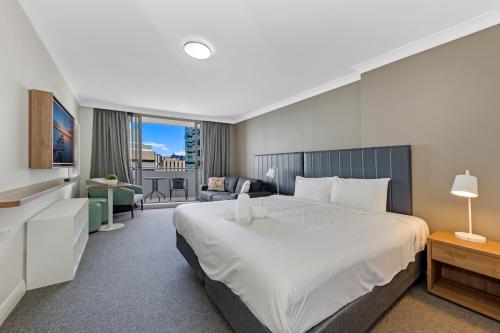 um quarto com uma cama grande e uma sala de estar em Comfy Studio Next to Chatswood Station em Sydney