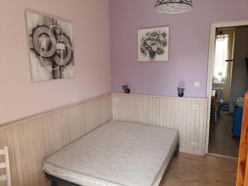 - un lit dans une chambre avec 2 photos sur le mur dans l'établissement Villa Géraniums apt 4, à Mont-Dore