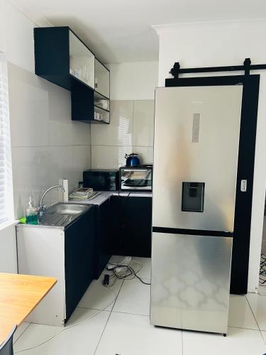 a kitchen with a refrigerator and a sink at Private garden guest house in Cape Town