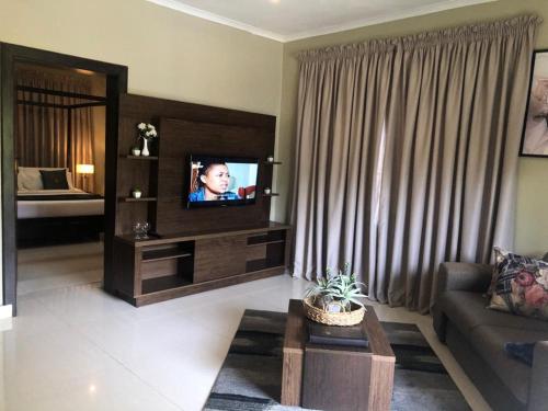 a living room with a couch and a television at Lotus by Serendib in Blantyre