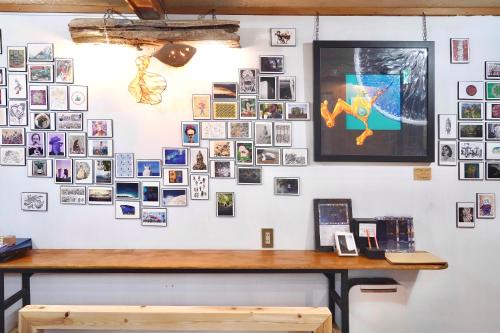 een muur vol foto's aan een muur met een bureau bij Minka House in Matsumoto