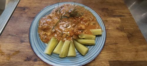 a blue plate with a bowl of food and some fruit at Zajazd pod Lwem in Trzebnica