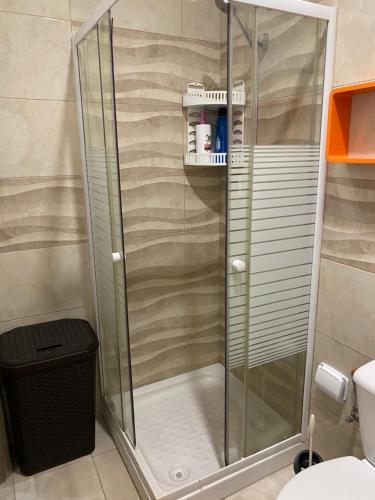 y baño con ducha y puerta de cristal. en DELUXE ROOM IN APARTMENT SHARED in Los Cristianos Playa HabitaciónSTANZA air-conditioned, en Arona