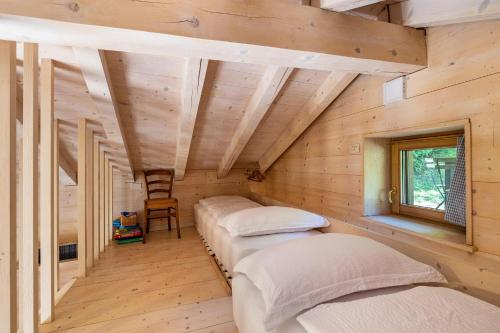 2 Betten in einem Zimmer mit Holzwänden in der Unterkunft Wunderchalet in Daone