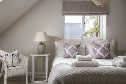 a bedroom with a bed with pillows and a window at Stone Barn, contemporary barn conversion in Cheltenham