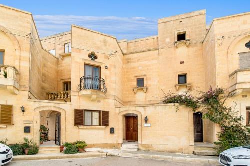 un gran edificio de ladrillo con balcón en Ta'Sandrija Pool And Well-Being In Gozo - Happy Rentals en Taʼ Bullara