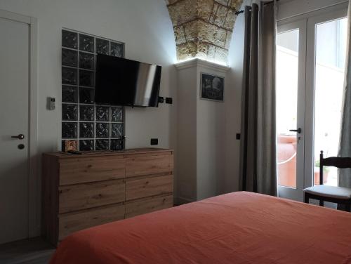 a bedroom with a bed and a dresser with a flat screen tv at La Casecchia in Porto Cesareo