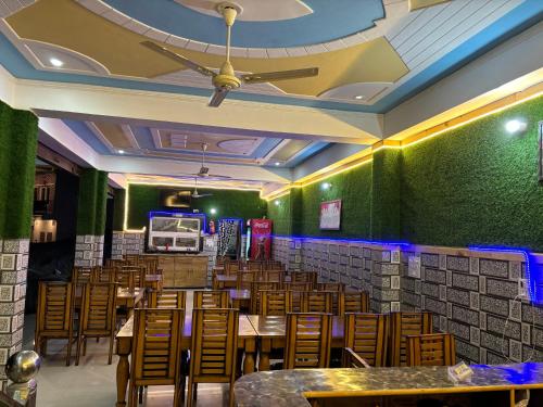 a restaurant with green walls and wooden tables and chairs at Uk09 hotel & Restaurant in Mussoorie